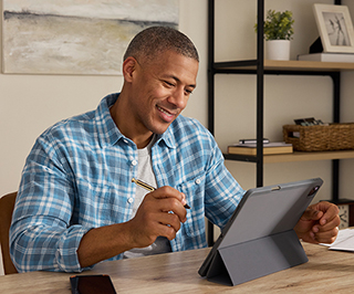 Man desk holding a stylus working on a tablet